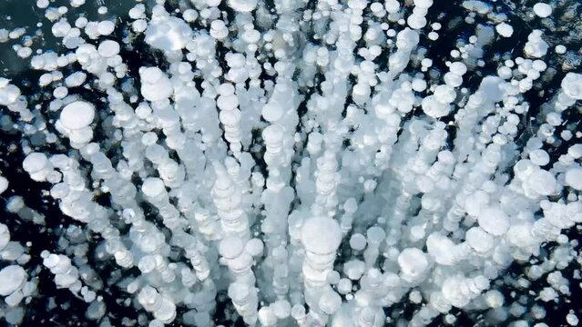 Frozen methane bubbles and cracks in the ice on Lake Baikal Siberia Russia. Natural cold background of ice. Winter abstract background. High quality 4k footage