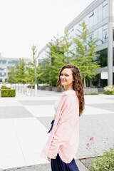 Happy pretty young brunette woman in pink oversized shirt