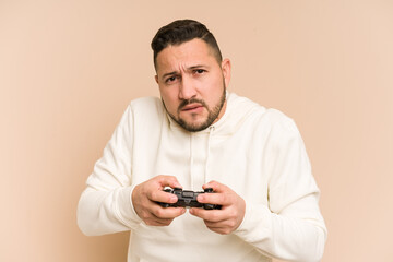 Adult latin man playing with a game controller isolated