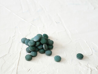 Green algae in pills spirulina on white background superfood