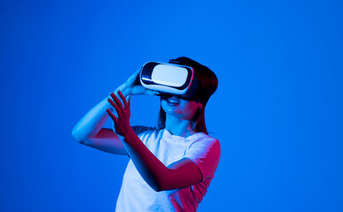 Brunette woman in VR glasses. Confident young woman in virtual reality headset pointing in the air...