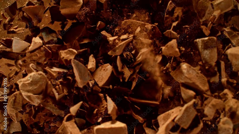 Poster super slow motion of rotating group of raw chocolate pieces. super fast camera motion. filmed on hig
