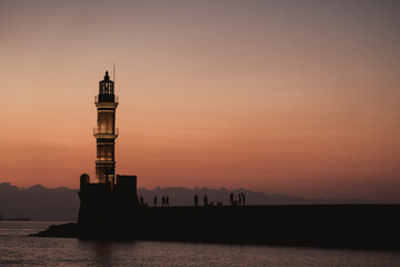 Chania, Greece, view of the old venetian lighthouse in the city harbour at sunset. 