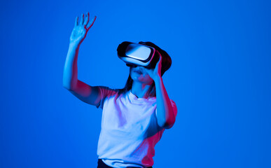Excited brunette woman in vr headset in a studio.