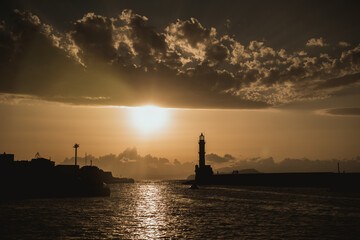 Chania, Greece, view of the old venetian lighthouse in the city harbour at sunset. 