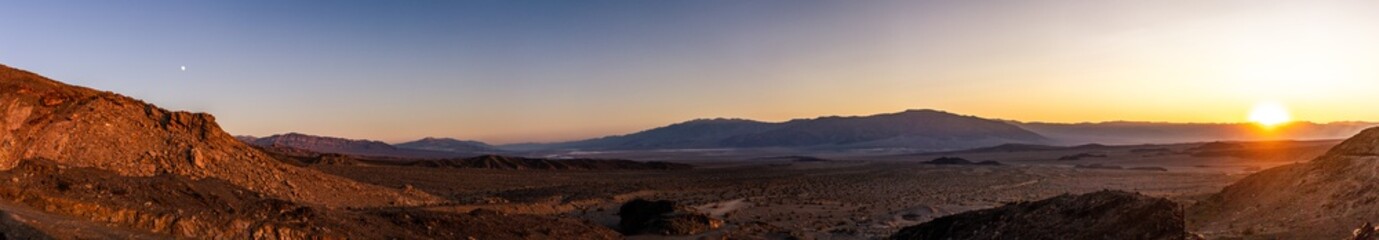 Fototapeta na wymiar Panorama view of sandy and rocky desert nature in Death Valley at sunset in america
