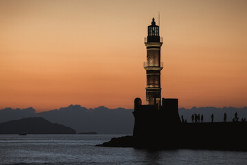 Chania, Greece, view of the old venetian lighthouse in the city harbour at sunset. 