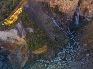 a stream of water flows down from a cave in the high rocks of the Caucasus. Mountain waterfall...