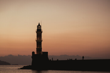 Chania, Greece, view of the old venetian lighthouse in the city harbour at sunset. 