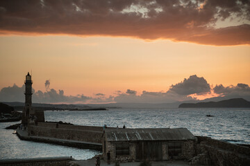 Chania, Greece, view of the old venetian lighthouse in the city harbour at sunset. 