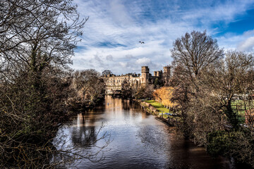 View on Warwick castle from bridge in autumn sunlight