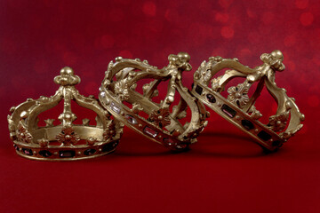 Happy Three King's Day. Three gold crowns on red background. Concept for Reyes Magos, Three Wise Men or Happy Epiphany day.
