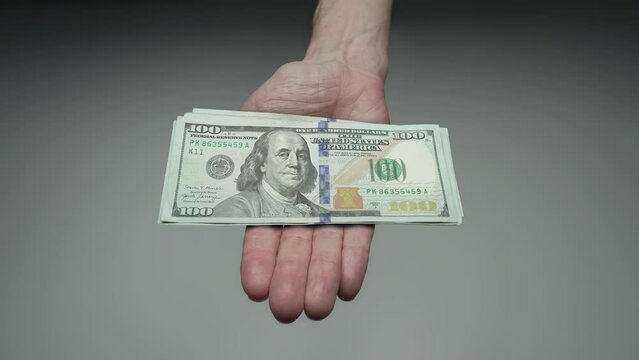 100 dollar bill shrinking over time  in palm of hand