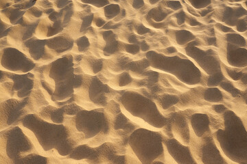 Sand in the desert with a pattern from the footprints as a background.
