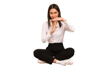 Young colombian woman sitting on the floor isolated showing a timeout gesture.