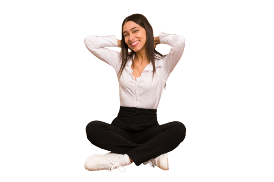 Young colombian woman sitting on the floor isolated stretching arms, relaxed position. - Powered by Adobe