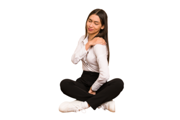 Young colombian woman sitting on the floor isolated having a shoulder pain.