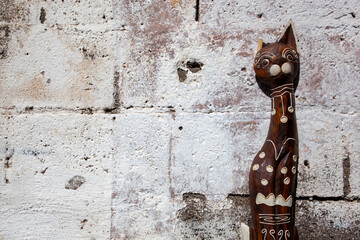 Wooden cat statue on a white wall