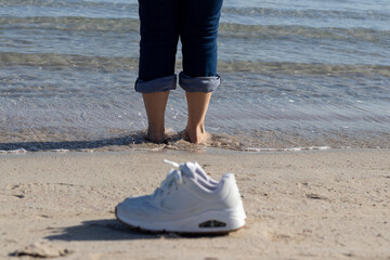 pies en remojo en la orilla de la playa con olas acariciando las piernas