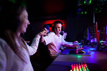 people play a computer in a computer club, a gamer guy in headphones is focused on the game, team play