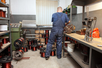 production of copper wire, a man works in a workshop at an electric engine plant