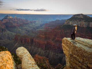 man standing on the edge of north rim of grand canyon