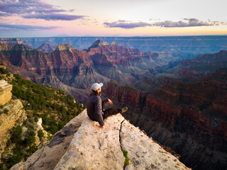man sitting on the edge of grand canyon © DEN