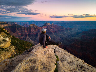 person on the top of north rim grand canyon at sunset