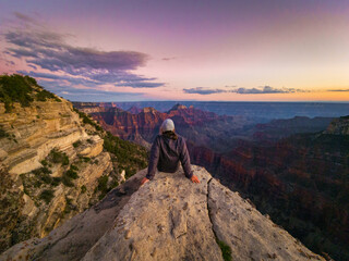 person looking into grand canyon at sunset