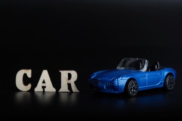 blue toy car miniature on a black background