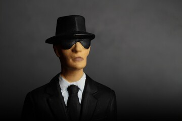 closeup portrait of a mysterious elegant man with sunglasses on a dark background