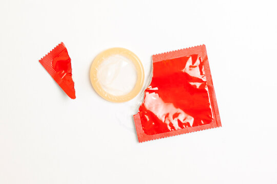 torn pack of condom on white background, top view, concept of safe sex