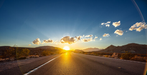 Empty long nevada mountain road to the horizon on a sunny summer day at bright sunset - obrazy, fototapety, plakaty