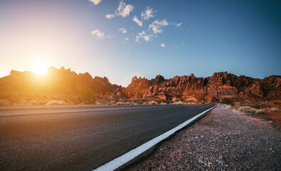 Empty long nevada mountain road to the horizon on a sunny summer day at bright sunset