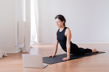 Young sporty slim woman coach internet video online training hatha yoga.