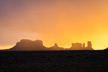 silhouettes of buttes and hoodoos in monument valley during sunrise