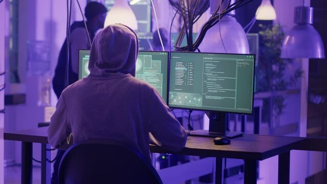 Police stopping people to do cyberterrorism, enforcing government operation and maintaining safety. Team of hackers running away from police lights at night, law enforcement. Handheld shot.