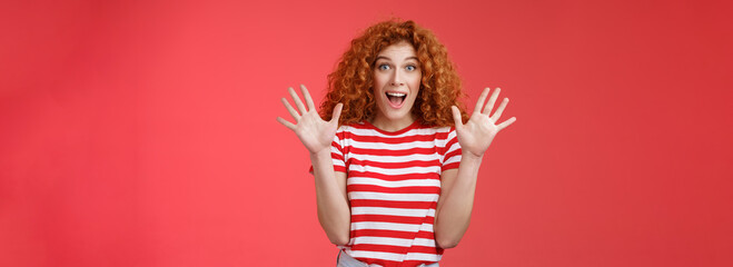 Extremely wonderful news she excited. Thrilled emotive gorgeous redhead woman scream amazed awesome surprise raise hands waving impressed open mouth stare charmed fascinated red background
