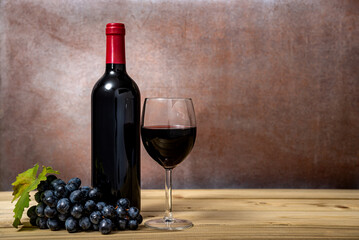 Red wine and grapes on wooden background