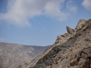 Fototapeta premium rostro de guardián descansando en la montaña con fondo de cielo azul, petroglifos de huancor, Peru, Sudamérica 