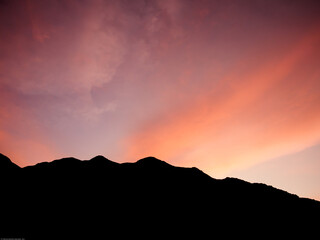 Silueta de montaña en atardecer colorido, cielo naranja, hora dorada