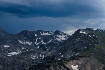 Snowy mountains surrounded by trees and rolling hills in Rocky Mountain National Park 