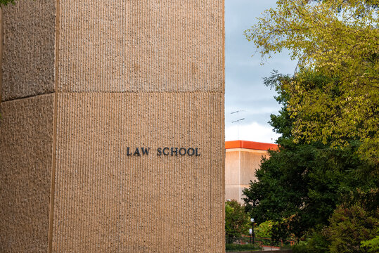 Close-up of law school text on brown textured wall at Stanford University with green tree growing in background at Palo Alto in California