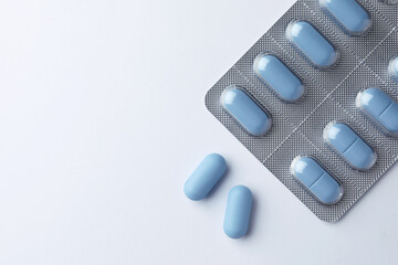 Pills and space for text on white background, top view. Potency problem