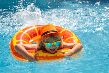 Kid boy relaxing in pool. Child swimming in water pool. Summer kids activity, watersports. Summer vacation with children. Child enjoying summer in the water in the swimmingpool.