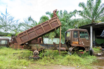 Fototapeta premium Side view of a broken down brown truck with it's container half lifted taken in the midday