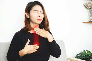 Asian woman suffering from acid reflux or gastroesophageal reflux disease (GERD) feeling uncomfortable and burning chest move up to neck and throat - obrazy, fototapety, plakaty