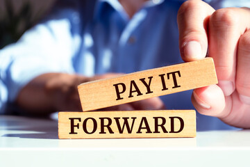 Wooden blocks with words 'PAY IT FORWARD'. Business concept