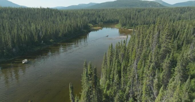 Stunning aerial flyover shot of a canoe on the Flowers River in Labrador, Canada