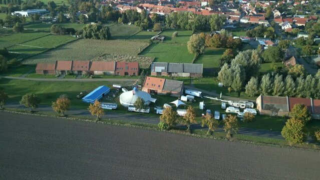 Small village, Kremmen on country road. Calm aerial view flight panorama orbit drone
brandenburg circus tent golden houre 2022. 4k marnitz Cinematic
